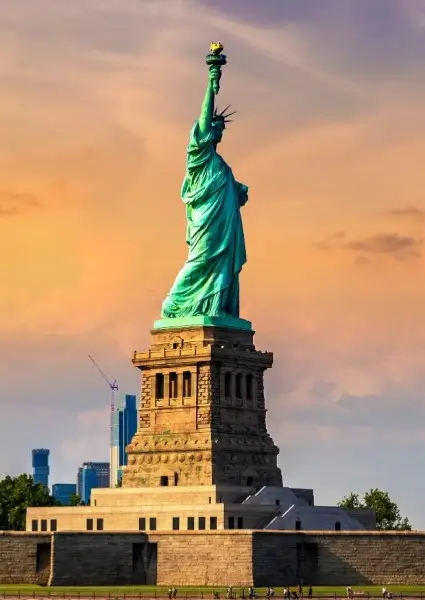 the statue of liberty stands in front of the city skyline